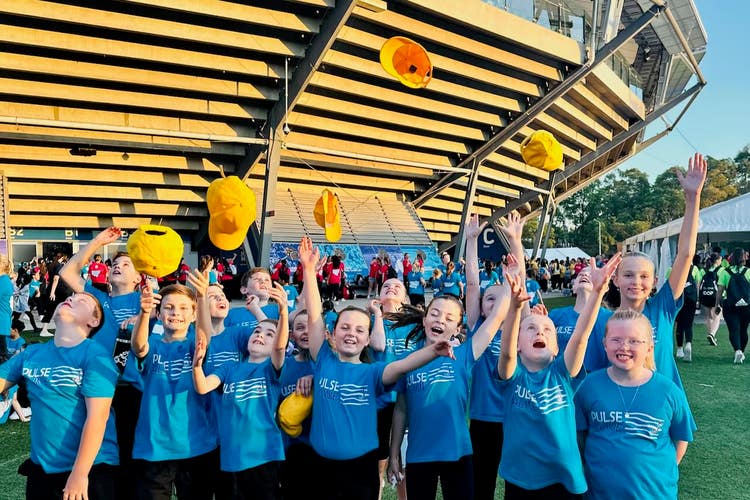 A picture of a group of children tossing their hats in the air with joy.