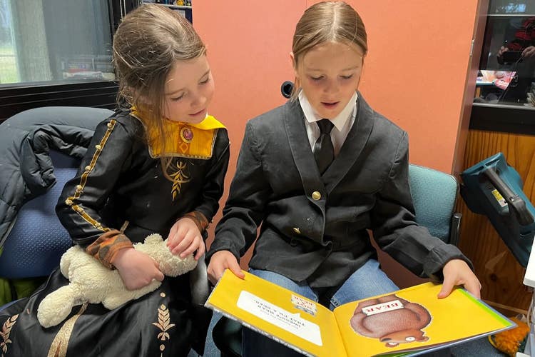 A picture of two students reading a book together