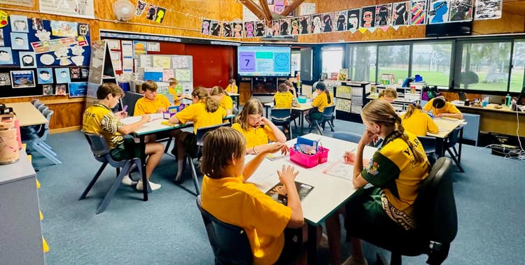 a picture a classroom with students sitting at their desks attending to their work