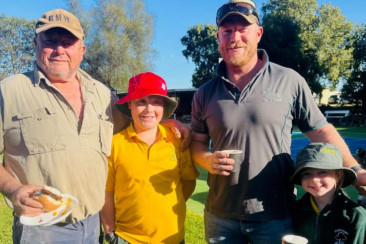 A picture of two students with their father and grandfather enjoying breakfast.