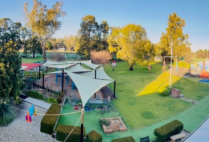a picture of the school grounds as seen from above showing shade sails, green lawns and a flag pole.